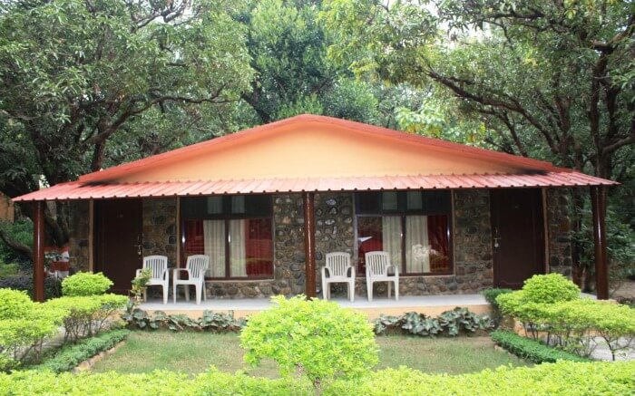hut like hotel with four plastic chair in the garden