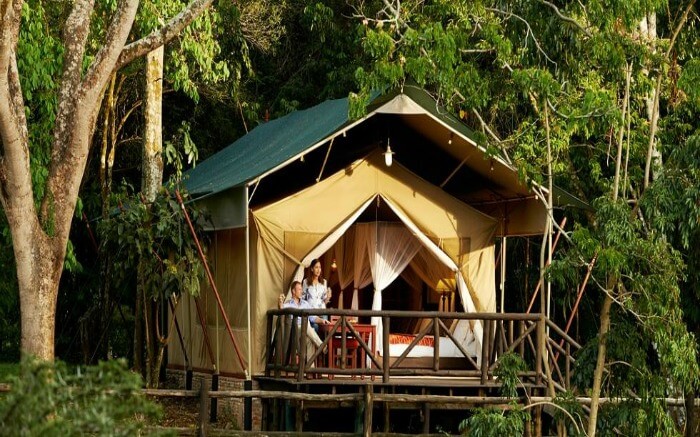 Couple sitting in the open air seating area of a tent in Fairmont Mara Safari Club