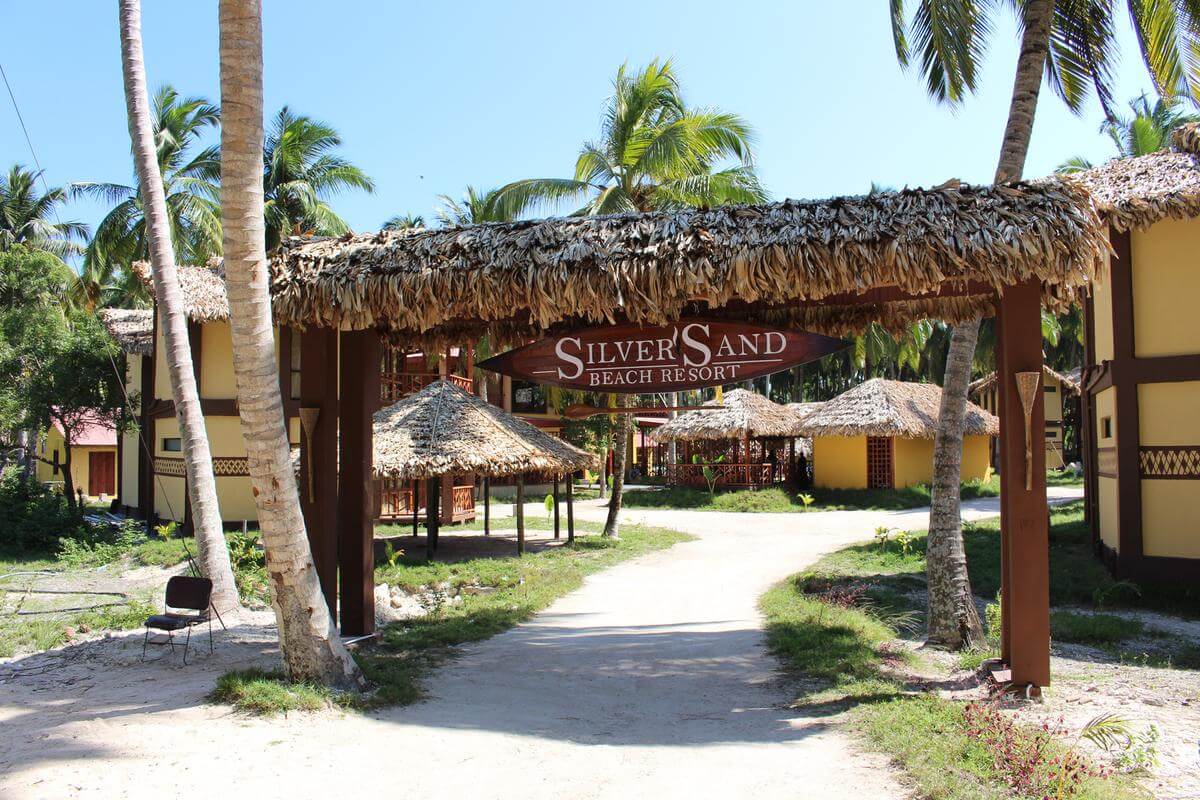 entrance of a beautiful resort with small huts in lawn