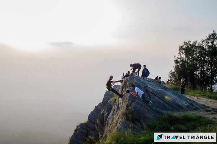 a group of people rock climbing in M