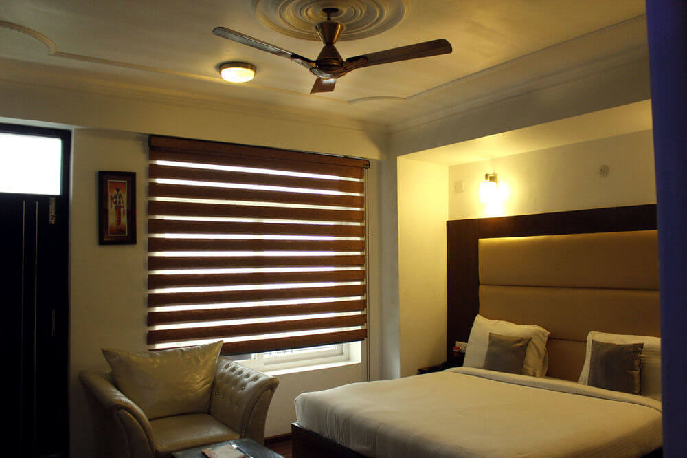 a modern hotel room with big bed an d a curtain