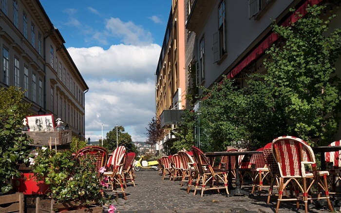 a cafe on street with red and white chairs