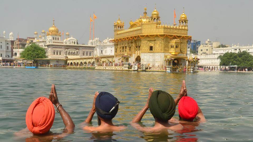 4 men praying in Golden Temple
