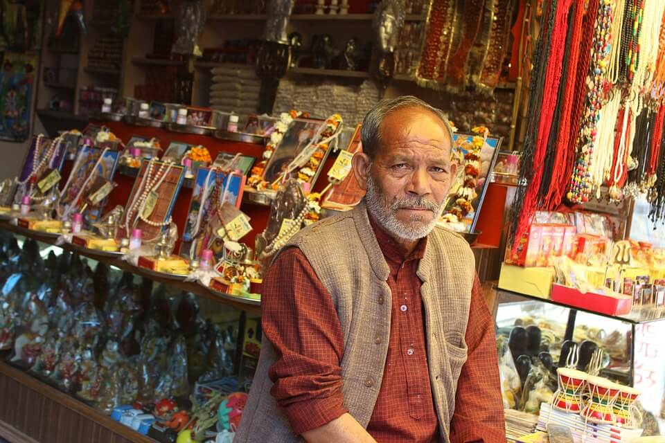 an old man sitting at his shop