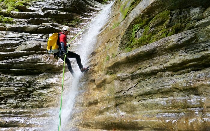 A man doing waterfall rappelling