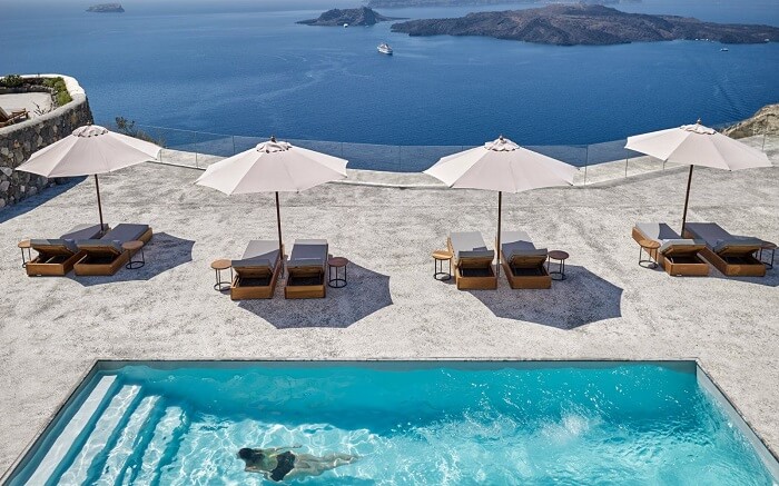 Sundecks and sun umbrella near the outdoor pool in a resort