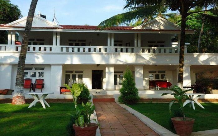 beautiful white Malabar Beach Resort with green lawn