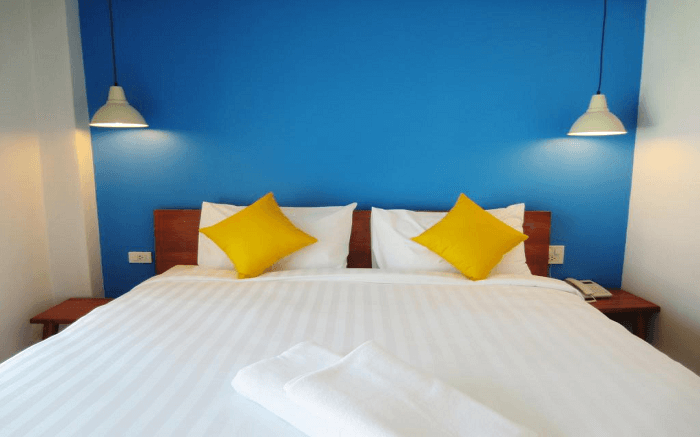 blue wall, yellow pillows in a room of Sleep Whale Express