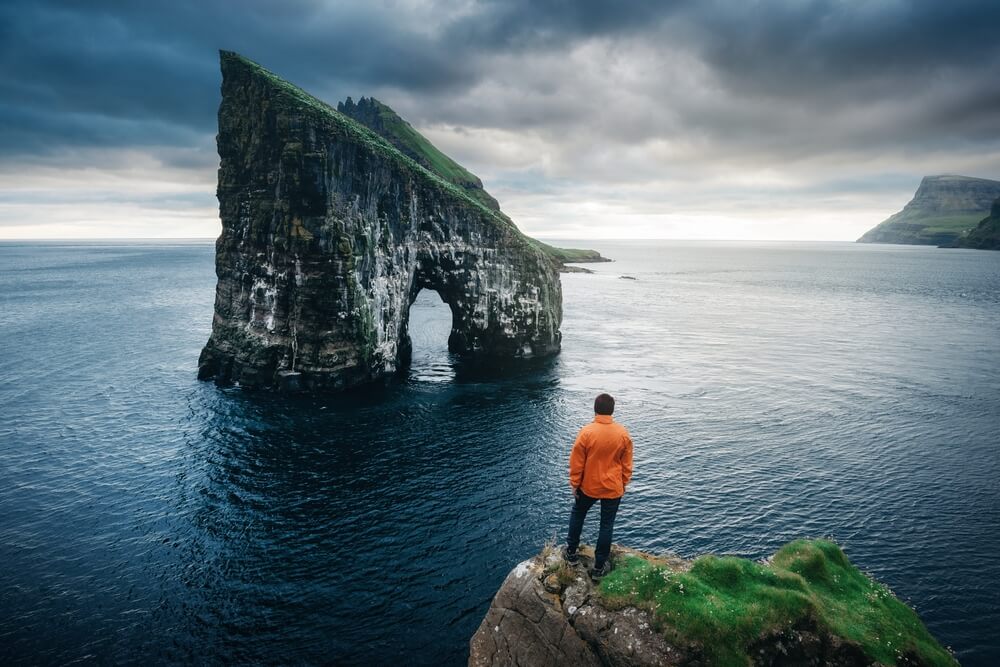 a man standing at the edge of an ocean