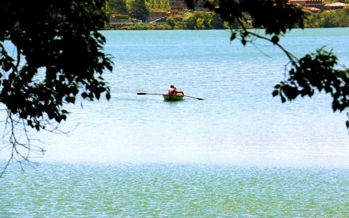 somebody rowing their boat in Bhimtal Lake